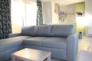 德帕內的住宿－De Panne - Adinkerke - 't Voetbrugsje comfortabele nieuwbouw，客厅配有蓝色的沙发和桌子