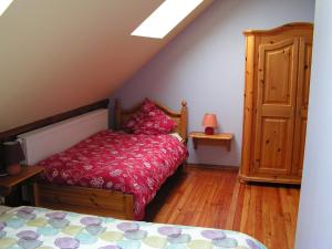 Schlafzimmer mit einem Bett mit einer roten Bettdecke in der Unterkunft Gîtes du Kreuzweg in Le Hohwald