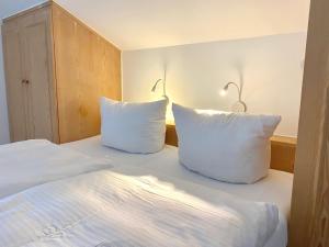 1 dormitorio con 2 almohadas blancas en una cama en Gemütliche Ferienwohnung am Tegernsee - ruhig im Dachgeschoss, en Bad Wiessee