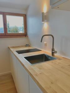 encimera de cocina con fregadero y ventana en Gemütliche Ferienwohnung am Tegernsee - ruhig im Dachgeschoss, en Bad Wiessee