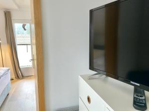 einen Flachbild-TV auf einer Kommode in der Unterkunft Gemütliche Ferienwohnung am Tegernsee - ruhig im Dachgeschoss in Bad Wiessee