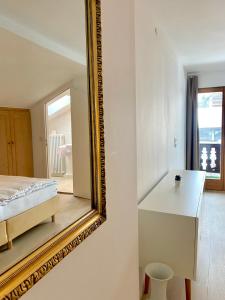 ein Schlafzimmer mit einem Spiegel, einem Bett und einem Tisch in der Unterkunft Gemütliche Ferienwohnung am Tegernsee - ruhig im Dachgeschoss in Bad Wiessee