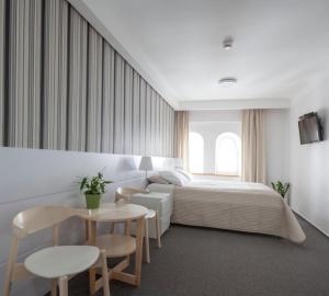 ein Schlafzimmer mit einem Bett, einem Tisch und Stühlen in der Unterkunft Apple Inn in Warschau