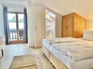 ein Schlafzimmer mit einem großen Bett und einem großen Fenster in der Unterkunft Gemütliche Ferienwohnung am Tegernsee - ruhig im Dachgeschoss in Bad Wiessee