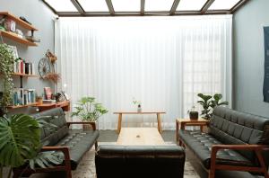 a living room with leather couches and a table at Journey Hostel in Tainan