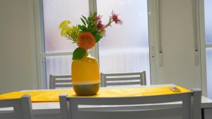 un jarrón con flores en él sentado en una mesa en Spacious Modern Family Apartment - Centre & Near Beach en Alicante