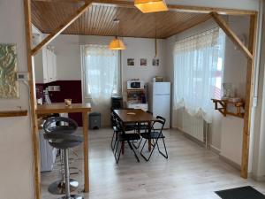 a kitchen and dining room with a table and a refrigerator at Crème in Les Chabottes