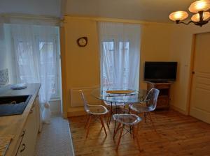 a kitchen with a table and chairs and a television at Studio Marie in Annonay