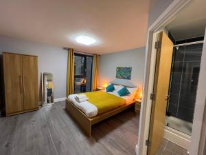 a bedroom with a bed with yellow sheets and blue pillows at Stunning Top Floor Southside Apartment 2 BEDS PARKING WIFI NETFLIX in Birmingham