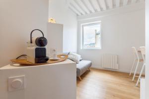 a white living room with a couch and a table at Shiro - Appartement 2beapart in Lyon