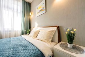 um quarto com uma cama com um cobertor azul e uma janela em Центр, 20 поверх! 2к квартира із панорамою em Kiev