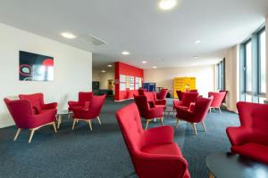 een wachtkamer met rode stoelen en tafels bij For Students Only Private Bedroom with Shared Kitchen at Athena Hall in Ipswitch in Ipswich