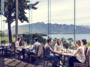 a group of people sitting at tables in a restaurant at Mercure Queenstown Resort in Queenstown