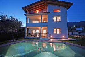 a house with a swimming pool in front of a house at la Luna nel Lago in Roe