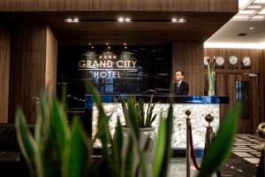 a man standing at a podium in a grand city hotel at Hotel Grand City Wrocław in Wrocław