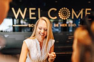 a woman laughing in front of a store at Panoramahotel Am Sonnenhang in Tirolo