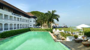 a swimming pool in front of a building at Brunton Boatyard - CGH Earth in Cochin