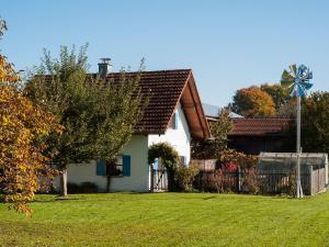 ein weißes Haus mit einer Windmühle im Hof in der Unterkunft Ferienhaus Wolferstetter in Tittmoning