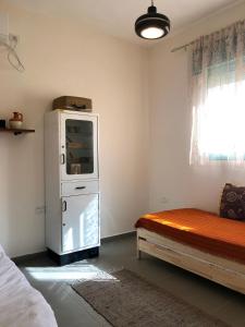 a room with a refrigerator and a bed in it at יעלת חן Ya'alat hen in Yeroẖam