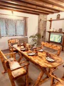 uma mesa de madeira e cadeiras numa sala de estar em Къща за гости На Мечка em Oborishte