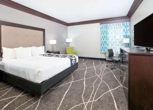 Habitación de hotel con cama, escritorio y TV. en La Quinta by Wyndham Little Rock - Bryant, en Bryant