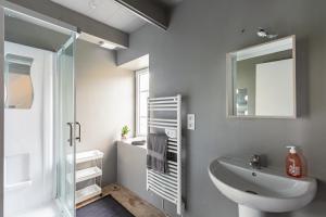 a bathroom with a sink and a toilet and a mirror at La Grand Voile - maison 4 chambres vue mer - plage à 900 m in Saint-Pol-de-Léon +14 photos