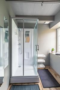 a bathroom with a shower with a glass door at La Grand Voile - maison 4 chambres vue mer - plage à 900 m in Saint-Pol-de-Léon