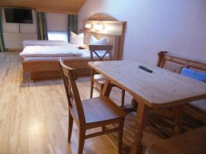 a room with a table and a bed and a bedroom at Gasthof Pension Altwirt in Sachsenkam