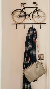 a bike hanging on a wall with a scarf and a purse at Old Town Suite in Krakow