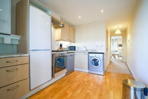 a kitchen with a refrigerator and a washer and dryer at Huntley House in Milton Keynes