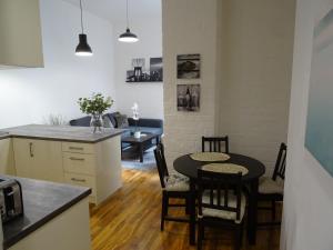 een keuken en een woonkamer met een tafel en stoelen bij The Holmé in Leicester