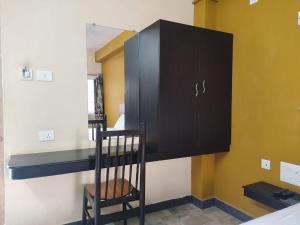 a bedroom with a bed and a desk and a chair at Balaji Lodge in Villupuram