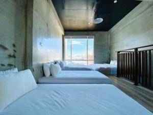 a bedroom with two beds and a large window at 40Inn Backpackers Warehouse in Taitung City