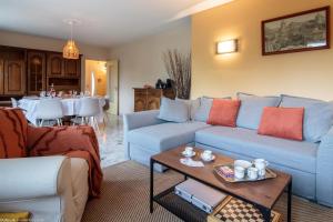 a living room with a blue couch and a table at Le gîte des 3 Arches in Genay