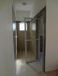 ein Badezimmer mit Dusche mit Glastür in der Unterkunft Vila Monrealle in Ubatuba