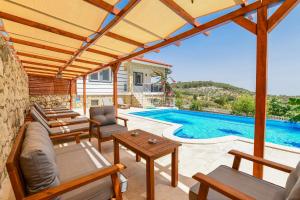 patio con sofá y sillas y piscina en Villa Moonlight, en Karadere