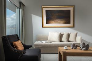 - un salon avec un canapé et une table dans l'établissement Hotel Matheo Villas & Suites, à Mália