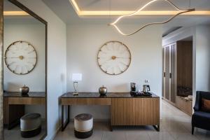 a lobby with two clocks on the wall and a desk at Hotel Matheo Villas & Suites in Malia