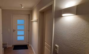 ein Flur mit einer Tür und einem Licht an der Wand in der Unterkunft Ferienhaus Bella Vista in Gelting
