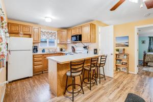 a kitchen with wooden cabinets and a white refrigerator at Cottage by the Bay in Ocean Park