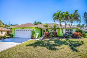 una casa verde con una palmera delante de ella en Casa del Limoncello, en Bonita Springs