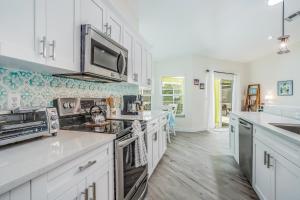 una cocina con armarios blancos y electrodomésticos blancos en Casa del Limoncello, en Bonita Springs