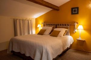 a bedroom with a large white bed with yellow walls at Chambre d'hôtes Belair in Muret