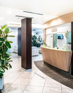 a lobby with a reception desk and potted plants at Hotel Lampara in Lignano Sabbiadoro