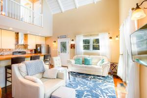 a living room with two couches and a kitchen at Pelican's Hideaway in Folly Beach