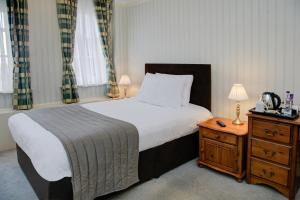 a bedroom with a bed and a table with a telephone at Old Hunstanton Le Strange Arms Hotel in Hunstanton