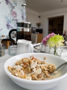 a bowl of cereal with a spoon in it on a table at Beaches Guest House in Southend-on-Sea