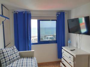 sala de estar con ventana y TV en Relaxlanzarote en Punta de Mujeres