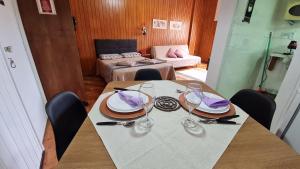 a table with plates and wine glasses on it at Estúdio 427 Teresópolis in Teresópolis