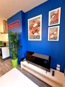 salon z telewizorem na niebieskiej ścianie w obiekcie Le Nintendo w mieście Liévin
